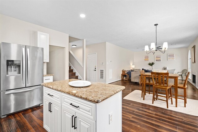 kitchen with a center island, white cabinetry, hanging light fixtures, stainless steel refrigerator with ice dispenser, and dark hardwood / wood-style flooring