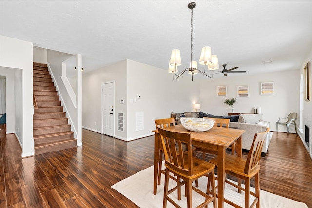 dining room featuring ceiling fan with notable chandelier and dark hardwood / wood-style floors