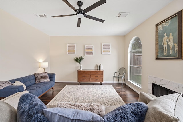 living room featuring a fireplace, dark wood-type flooring, and a healthy amount of sunlight