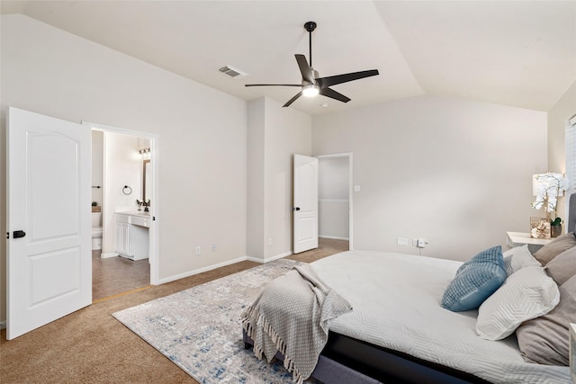 carpeted bedroom with ceiling fan, connected bathroom, and vaulted ceiling