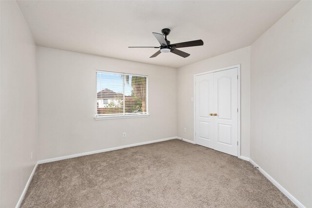 spare room with light colored carpet and ceiling fan