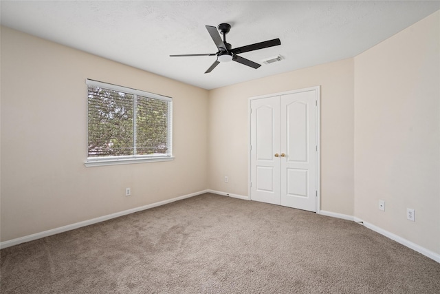 unfurnished bedroom featuring ceiling fan, a closet, and carpet