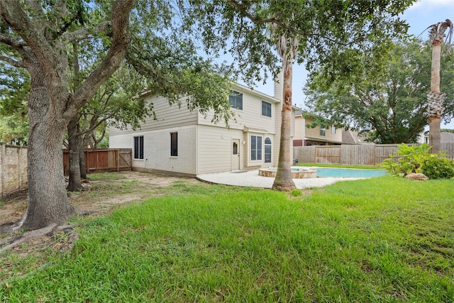 back of house with a yard, a fenced in pool, and a patio area