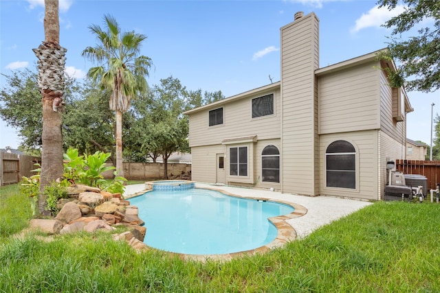 view of swimming pool featuring a pool with connected hot tub and a fenced backyard