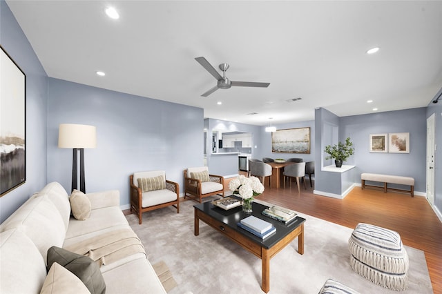 living room with ceiling fan and light wood-type flooring