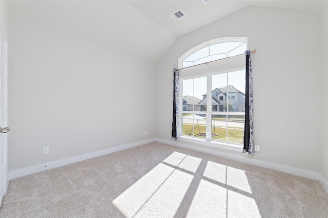 carpeted spare room with lofted ceiling and a wealth of natural light