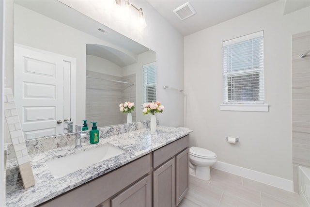 bathroom with tile patterned flooring, a tile shower, vanity, and toilet