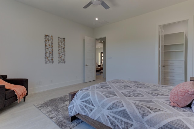 bedroom featuring a walk in closet, ceiling fan, and a closet