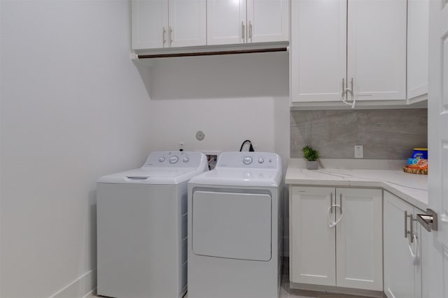 laundry room with washer and dryer and cabinets