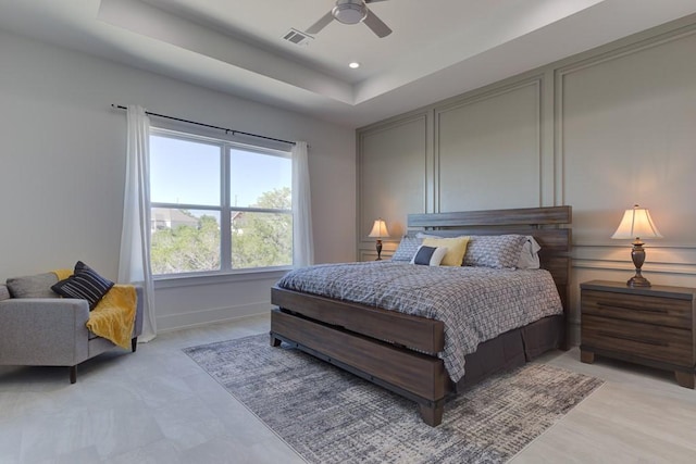 bedroom with ceiling fan and a tray ceiling