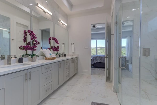 bathroom with walk in shower, a raised ceiling, and vanity