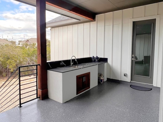 view of patio featuring sink, a balcony, and exterior kitchen