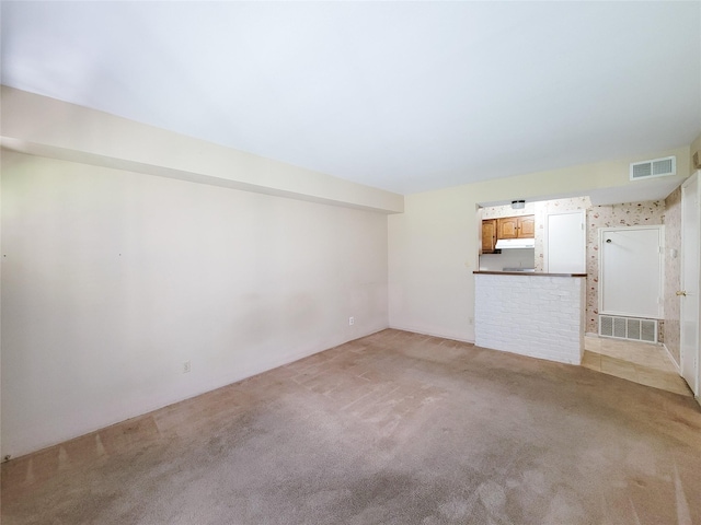 unfurnished living room featuring light colored carpet