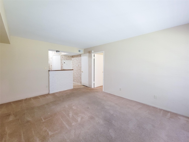 unfurnished living room with light colored carpet