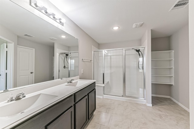 bathroom with tile patterned flooring, a shower with shower door, and vanity