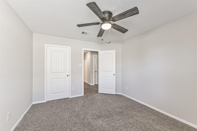 unfurnished bedroom with ceiling fan and dark colored carpet