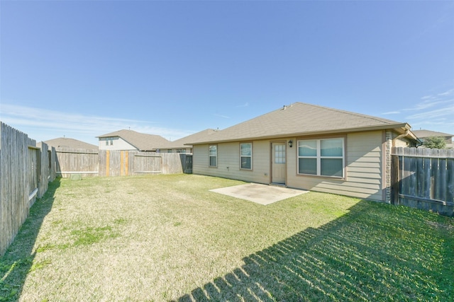 back of house featuring a patio area and a lawn