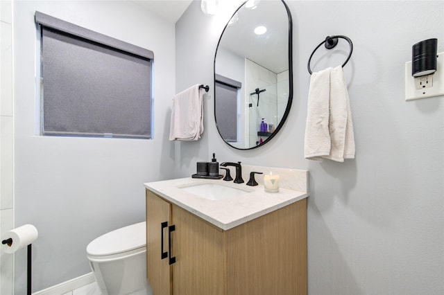 bathroom featuring toilet, a shower, and vanity