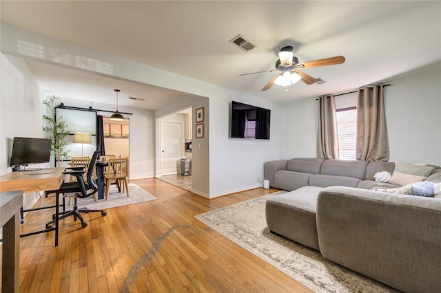 living room featuring ceiling fan and light hardwood / wood-style floors