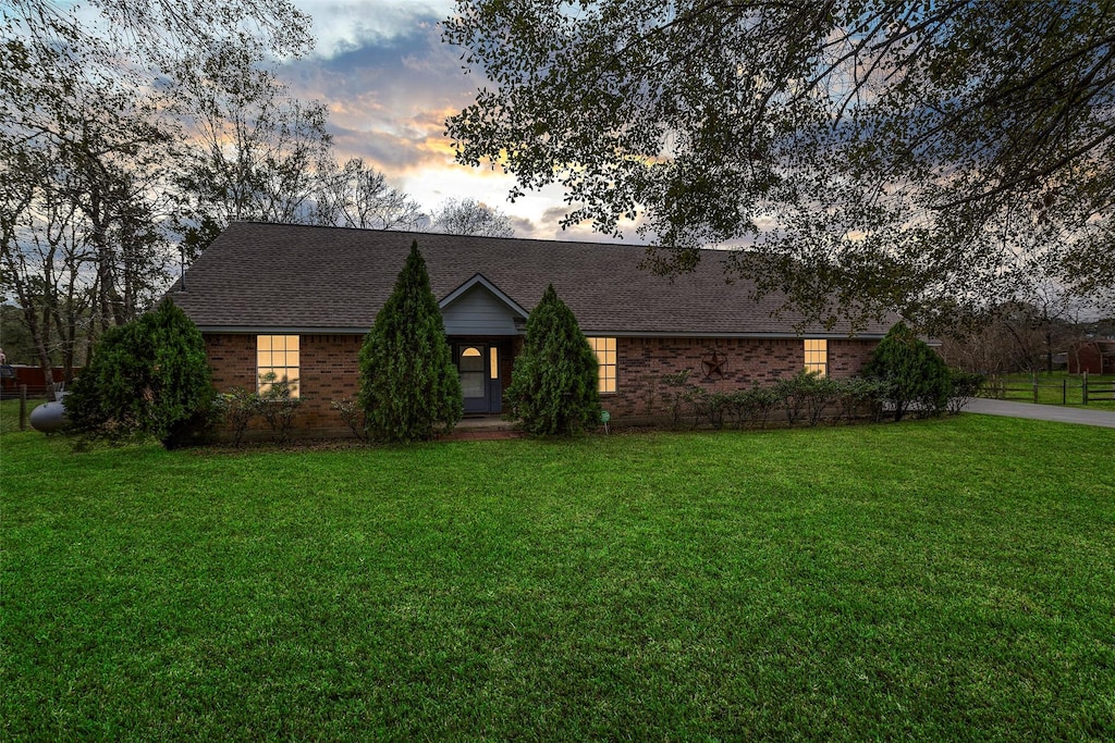 ranch-style home featuring a lawn