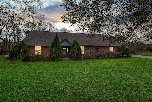 ranch-style home featuring a lawn