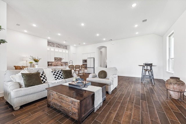 living room with vaulted ceiling and sink