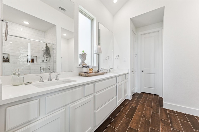 bathroom featuring vanity, vaulted ceiling, and a shower with shower door