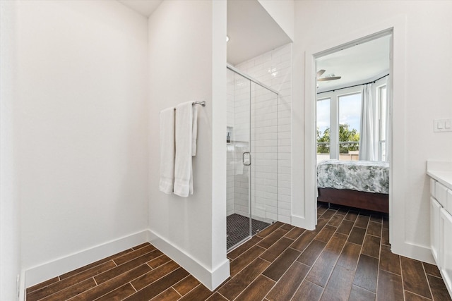 bathroom featuring ceiling fan, a shower with door, and vanity