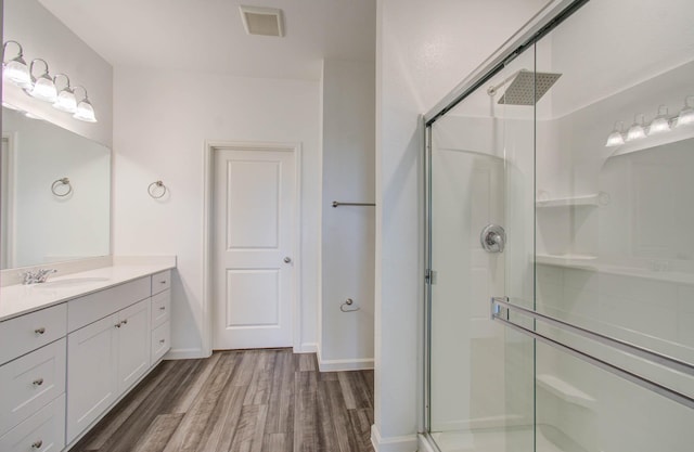 bathroom featuring vanity, a shower with shower door, and hardwood / wood-style floors