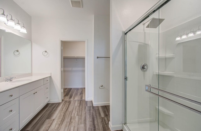 bathroom with an enclosed shower, vanity, and hardwood / wood-style flooring