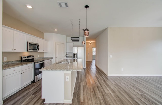 kitchen featuring sink, stainless steel appliances, white cabinetry, and decorative light fixtures