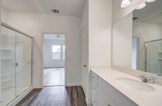 bathroom with hardwood / wood-style flooring, an enclosed shower, and vanity