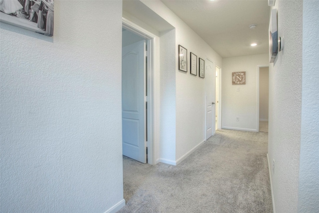 hall featuring light colored carpet