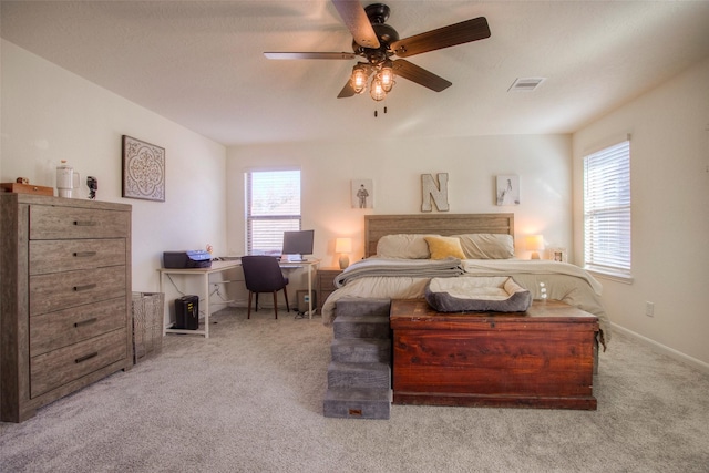 bedroom with light colored carpet, ceiling fan, and multiple windows