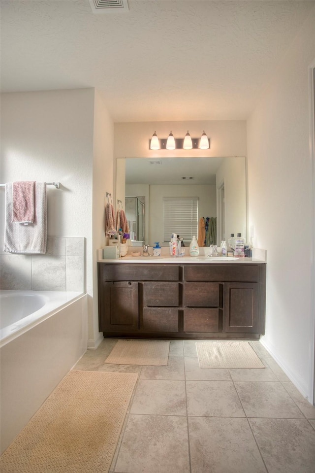 bathroom featuring tile patterned flooring, a tub, and vanity