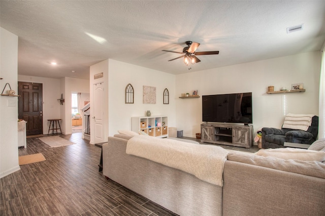 living room with a textured ceiling and ceiling fan