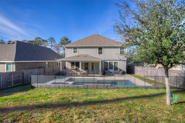 rear view of property with a yard, a fenced in pool, and a patio