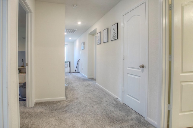 hallway featuring light colored carpet