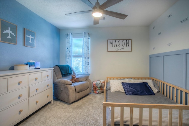 carpeted bedroom featuring a textured ceiling and ceiling fan