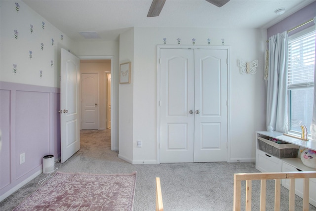 unfurnished bedroom featuring ceiling fan, a closet, and light carpet