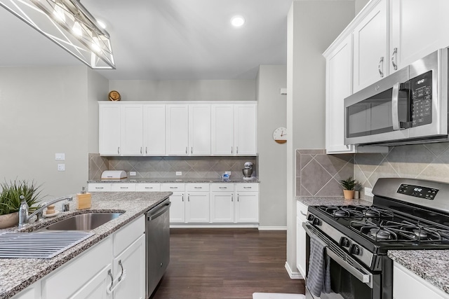 kitchen featuring stainless steel appliances, dark wood-type flooring, light stone counters, white cabinetry, and tasteful backsplash