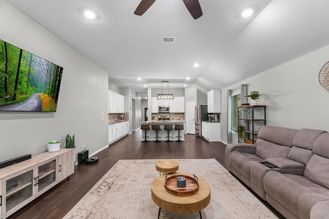 living room with lofted ceiling, ceiling fan, and dark hardwood / wood-style floors