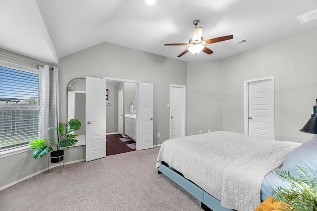 carpeted bedroom featuring lofted ceiling, ensuite bath, and ceiling fan