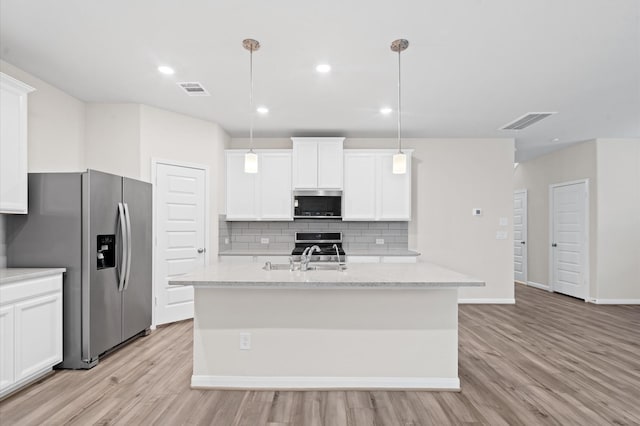 kitchen with decorative light fixtures, stainless steel appliances, decorative backsplash, and white cabinetry