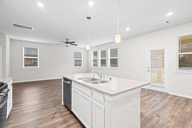 kitchen featuring sink, stainless steel appliances, white cabinets, light wood-type flooring, and hanging light fixtures