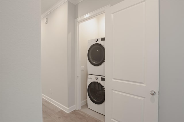 laundry area with light wood-type flooring and stacked washer and dryer