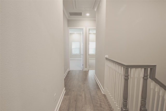 corridor with hardwood / wood-style floors and ornamental molding