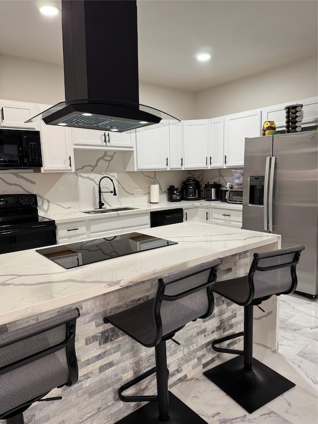 kitchen featuring a breakfast bar, island exhaust hood, black appliances, and sink