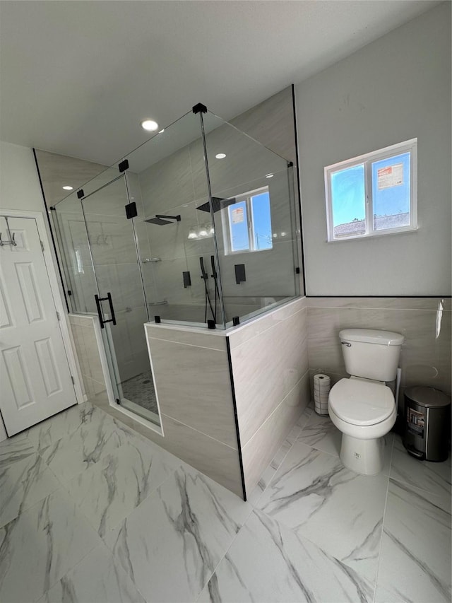 bathroom with toilet and a shower with door