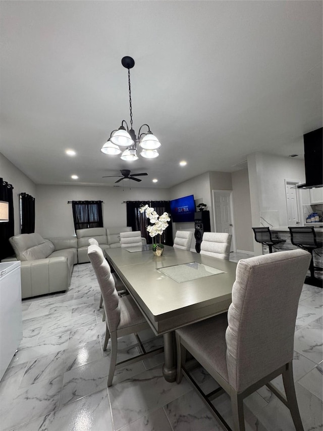 dining space featuring ceiling fan with notable chandelier